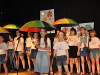 dzieci spiewające z parasolkami